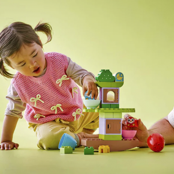 Padre e hijo jugando con LEGO en casa.